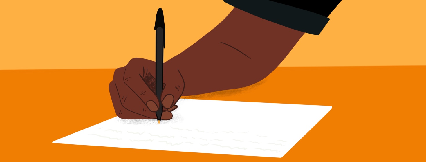 A hand writes a letter on a table