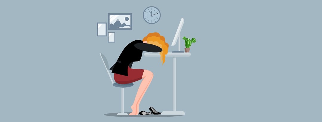 An image of a woman when her head down at a desk