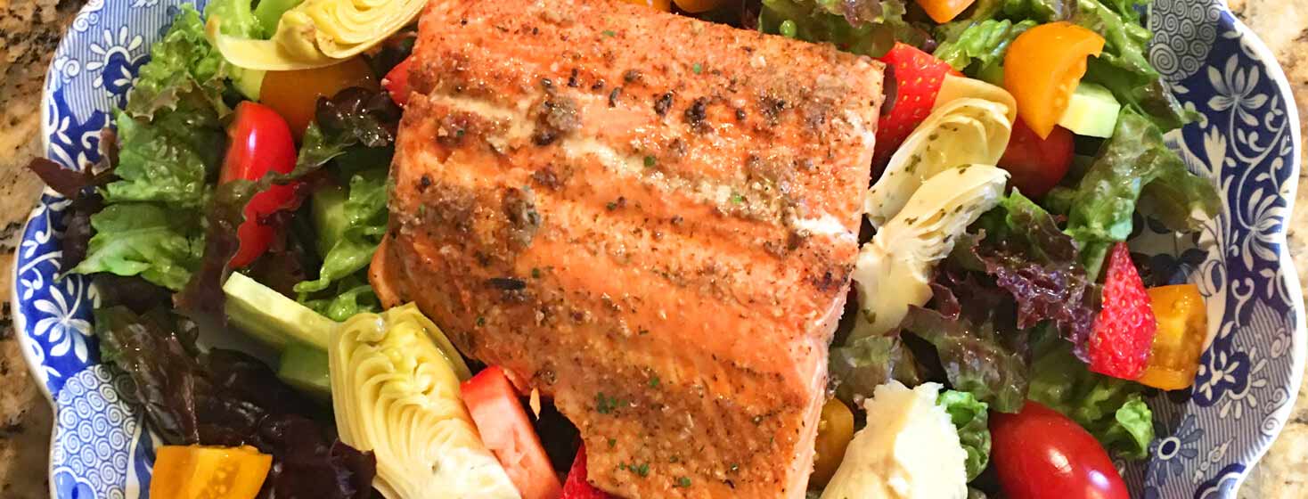 Salmon fillet on top of a summer salad.